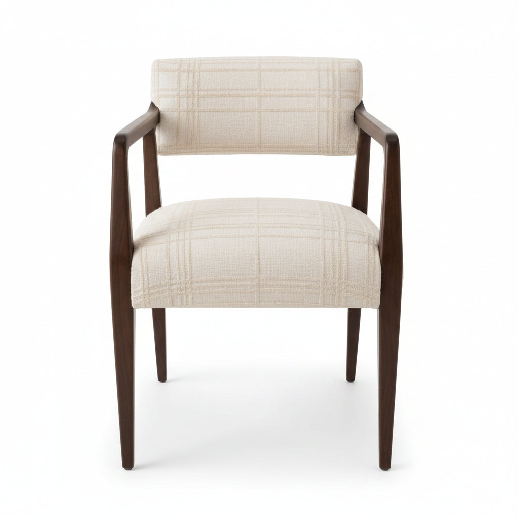 A wooden armchair with cream-colored textured fabric upholstery, shown in a home setting on a wood floor near a window.